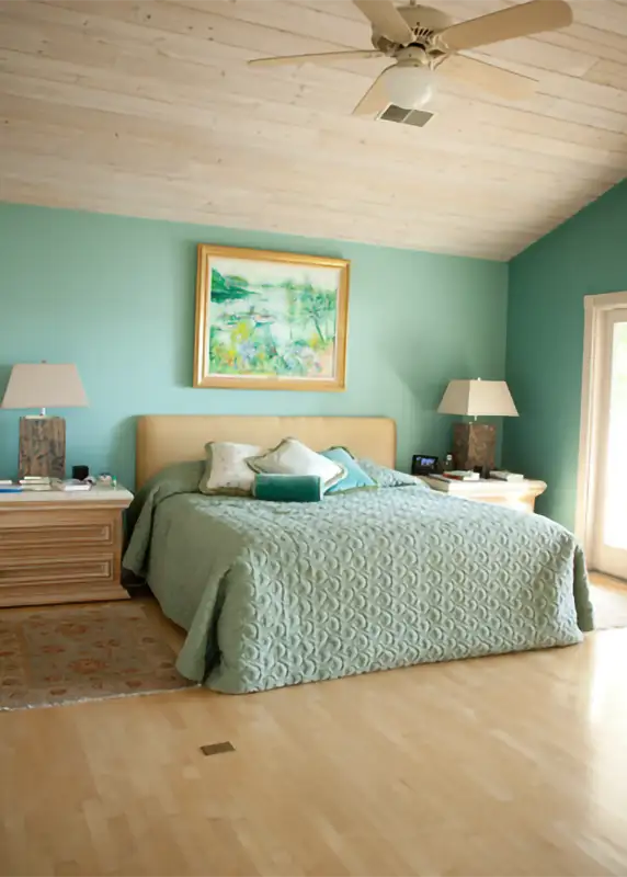 Coastal-inspired teal bedroom interior design by AFAR Imports & Interiors, Springfield, IL, showcasing custom bedding and wood ceiling accents