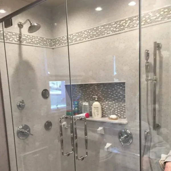 Custom-tiled walk-in shower renovation by AFAR Imports & Interiors, Springfield, IL, with mosaic accent border