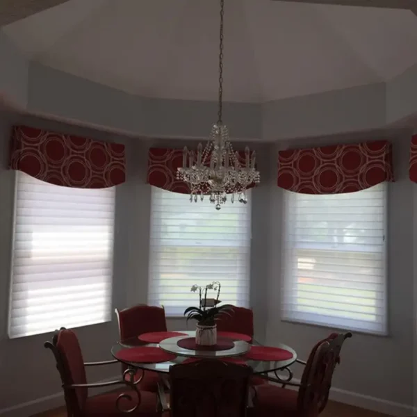 Custom red circle-pattern cornice valances over Roman shades by AFAR Imports & Interiors, Springfield, IL bay window treatment